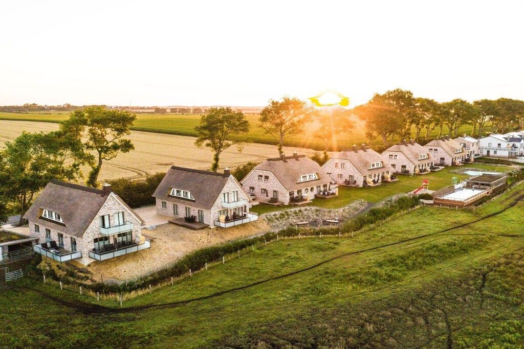 A row of houses with a grassy foreground and a clear sky.