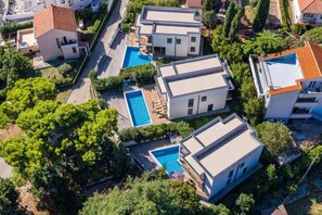 A residential area with modern houses, a swimming pool, and lush greenery. - Villas Paliska (Premantura)