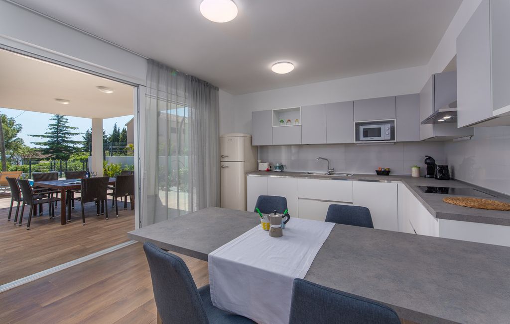 Una cocina moderna con comedor, microondas y refrigerador.