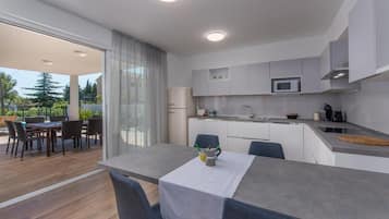 Una cocina moderna con comedor, microondas y refrigerador.