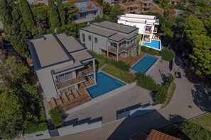 Un moderno edificio residencial de varios pisos con piscina y un área al aire libre techada.