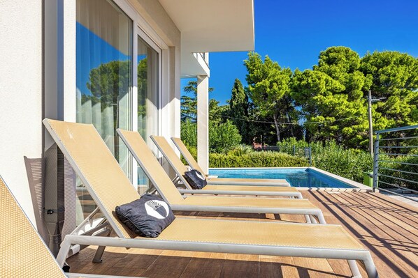 A poolside area with lounge chairs and a swimming pool.