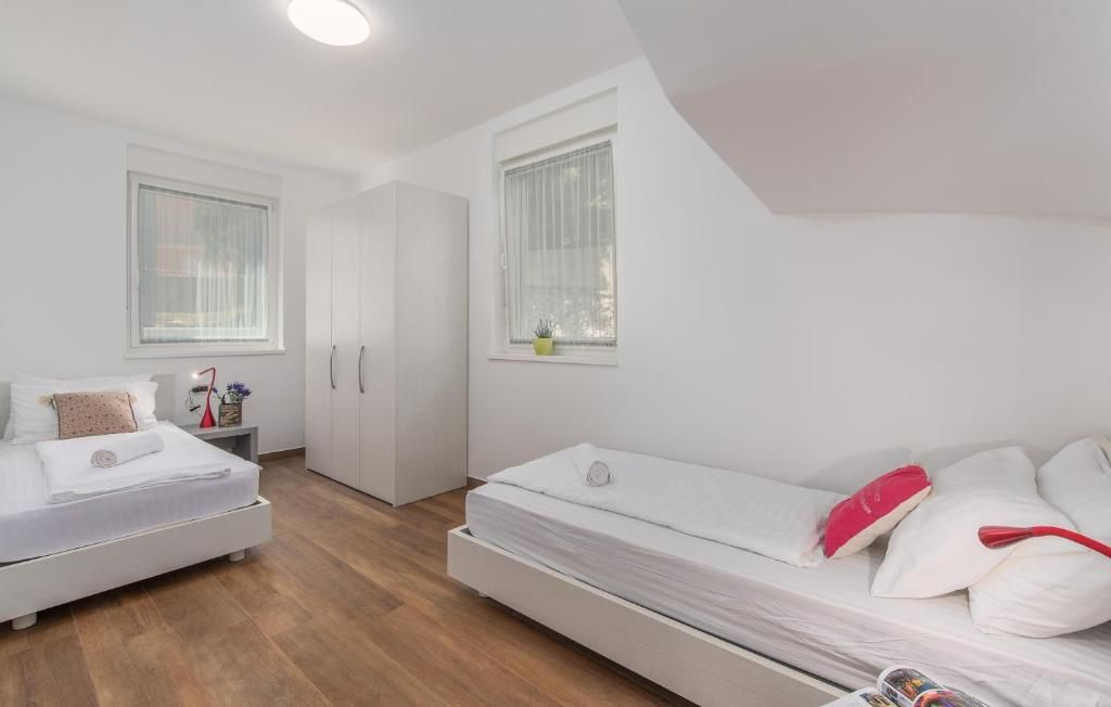 Un dormitorio con cama, mesita de noche, armario y ventana.