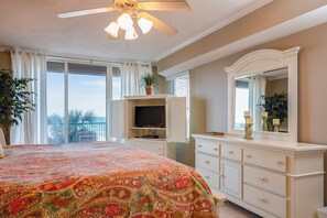 A bedroom with a large bed, a television, a dresser, and a ceiling fan. - Spacious Oversized Balcony on 2nd Floor - Great Ocean Views (Daytona Beach Shores)