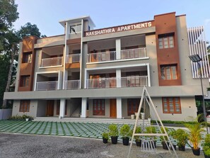 Ein mehrgeschossiges Wohngebäude mit Balkonen und einem Schild mit der Aufschrift 'NAKSHATRA APARTMENTS'.