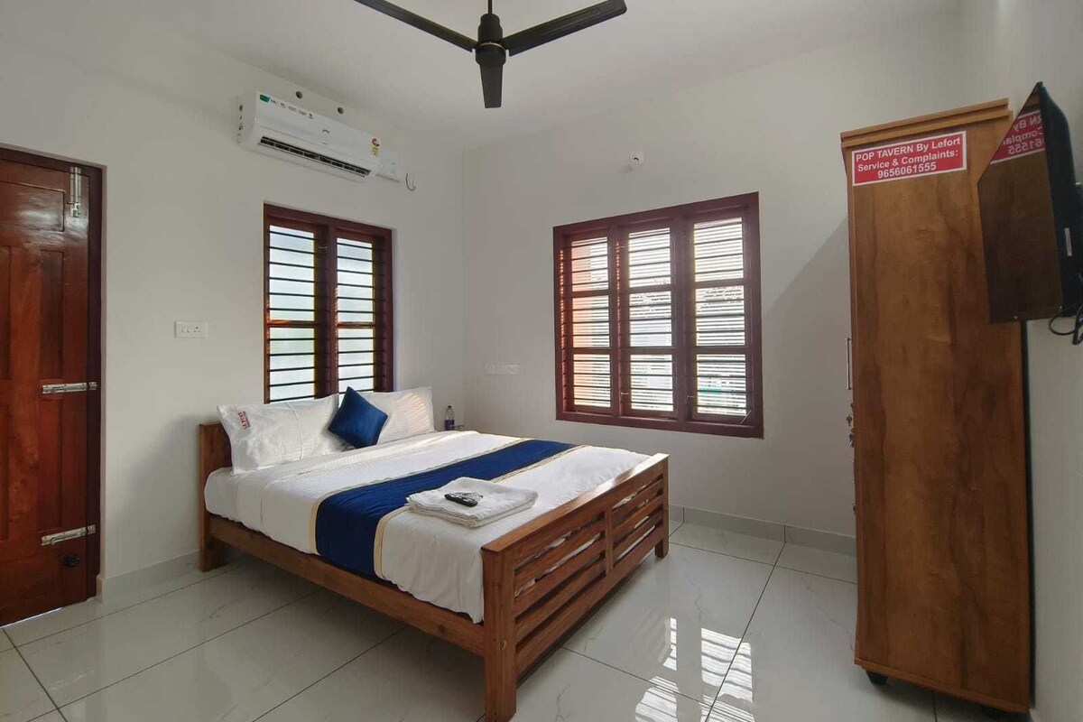 Ein Schlafzimmer mit Bett, Kleiderschrank, Deckenventilator und Fenstern.