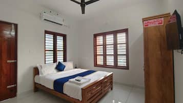 Ein Schlafzimmer mit Bett, Kleiderschrank, Deckenventilator und Fenstern.
