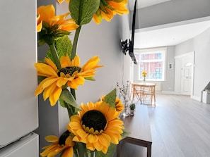 Un intérieur moderne comprenant un coin repas, une grande fenêtre et un luminaire fixé au mur.