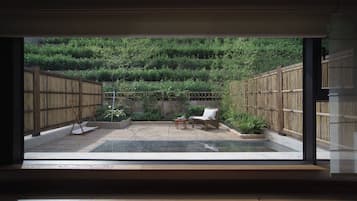 A room with a large window overlooking a bamboo garden.