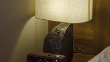 A bedside table with a lamp and a radio.