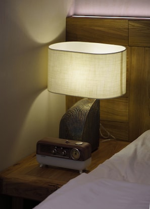A bedside table with a lamp and a radio.