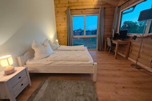 A bedroom with a bed, a desk, and a computer. - Golden Timber Lodge – Exklusives Ferienhaus in Selchow (Selchow)