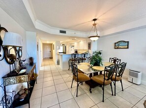 A dining area with a round table, chairs, and a pendant light. - Links N at Harbor Village B507 (Ponce Inlet)