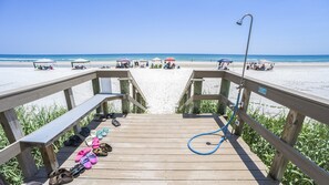 A wooden boardwalk leading to a beach with umbrellas and people. - #1004 Seychelles 3/3 Oceanfront Traffic Free Beach (Daytona Beach Shores)
