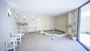 A spa area with a hot tub, seating, and potted plants. - #1004 Seychelles 3/3 Oceanfront Traffic Free Beach (Daytona Beach Shores)