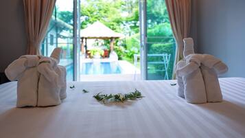 A hotel room with a bed, a view of a pool, and curtains.
