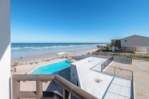 Piscina no terraço com vista para a praia e o oceano.