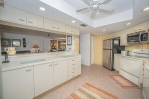 A kitchen with white cabinets, a stainless steel refrigerator, and a microwave. - #301 Seychelles Oceanview Traffic Free Beach (Daytona Beach Shores)