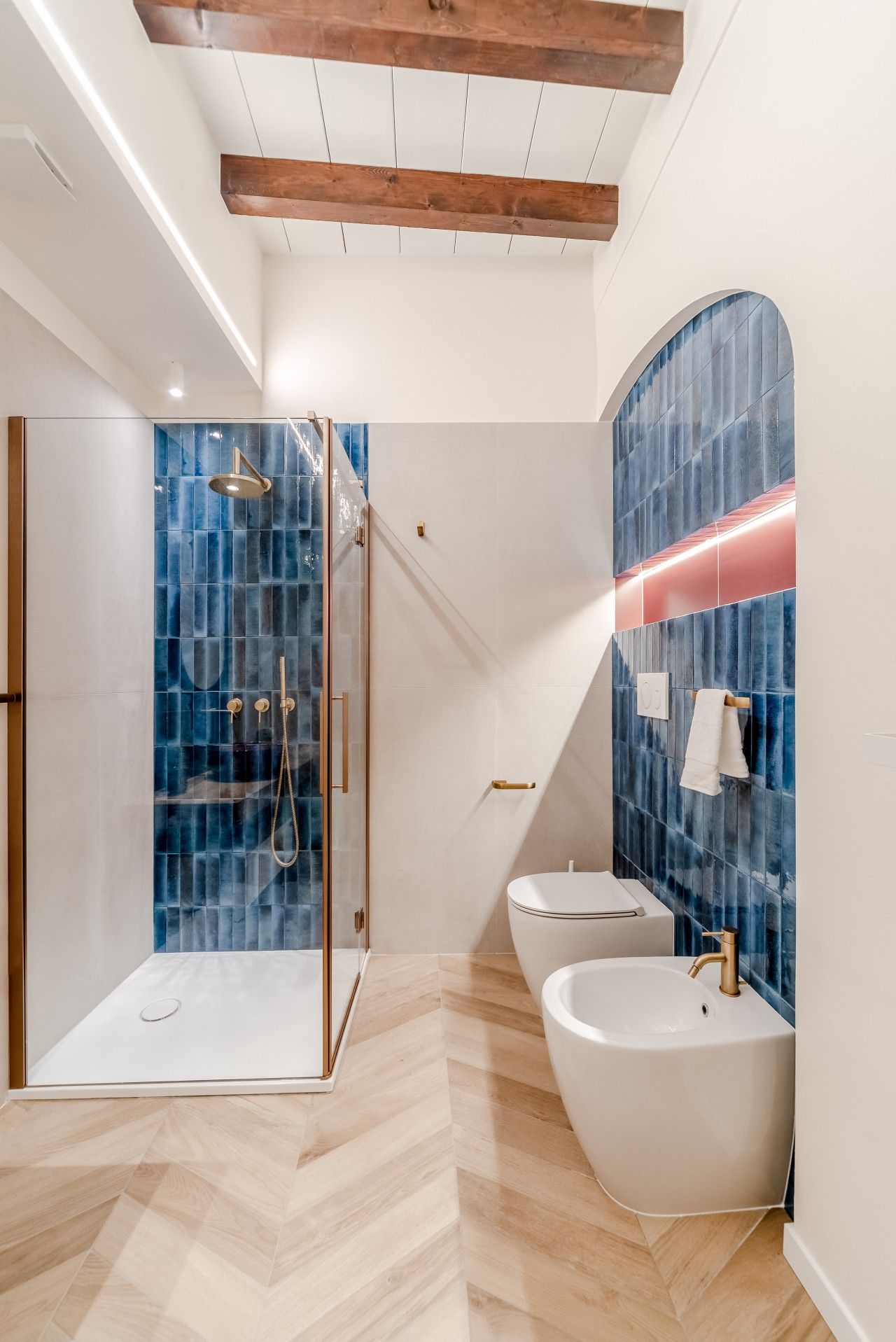 Ein modernes Badezimmer mit Duschkabine aus Glas, einer freistehenden Badewanne und einem Waschtisch mit großem Spiegel.