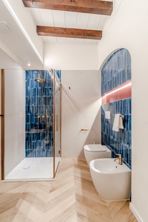 A modern bathroom with a glass shower enclosure, a freestanding bathtub, and a vanity with a large mirror. - Parco Ducale Design Rooms - Queen Room (Parma)