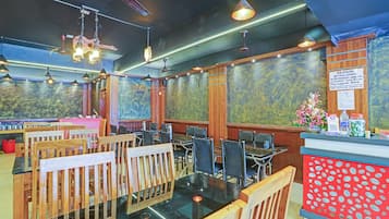 Un ristorante con arredi in legno, luci a sospensione e un bancone con il menu.