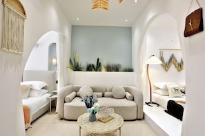 A modern living room with a sofa, a coffee table, and a lamp. There is a wall with a clock and a plant. - Shanghai Xiangyu Guesthouse (Shanghai)