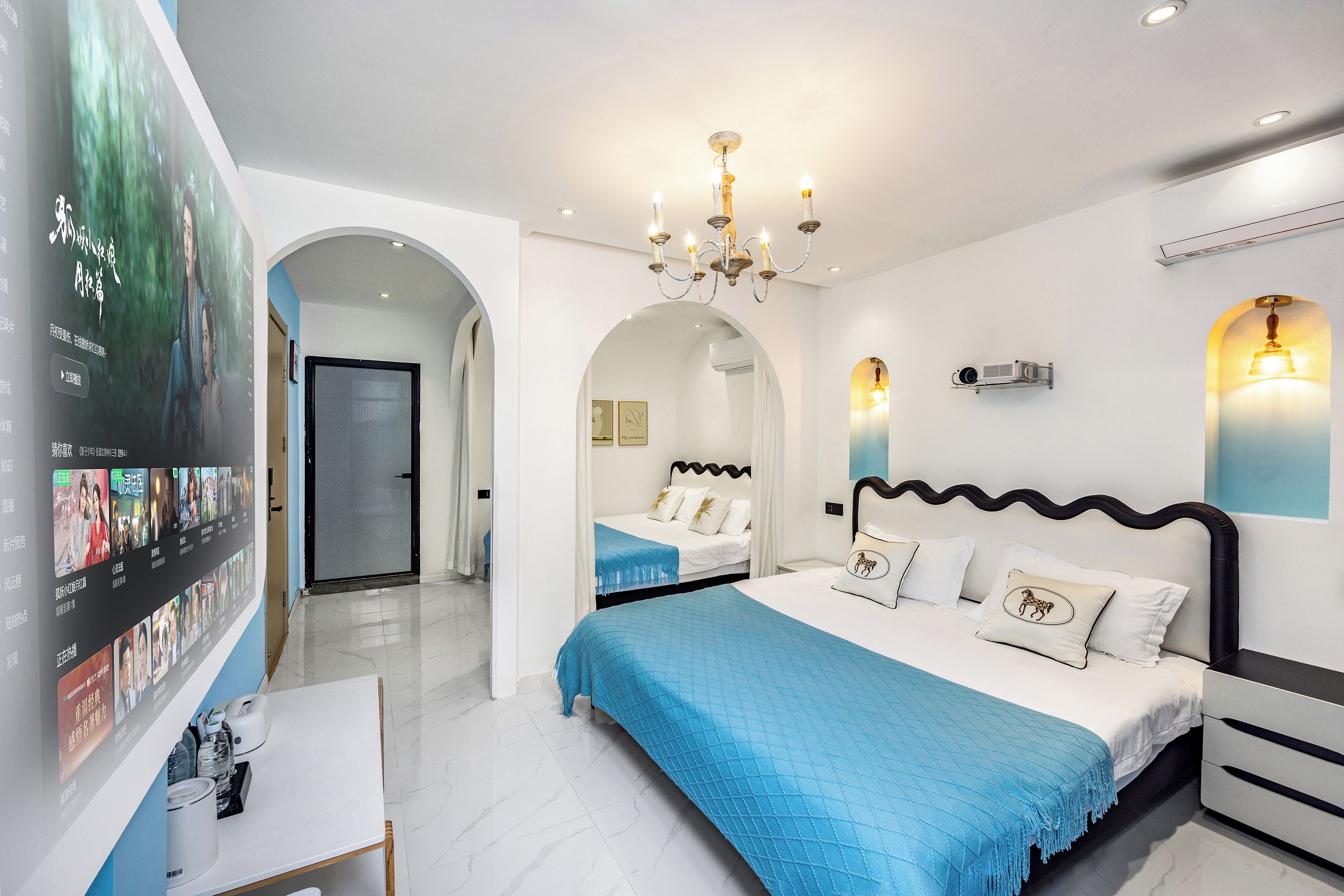 Een moderne hotelkamer met een groot bed, een bureau en een aan de muur bevestigde televisie waarop een film wordt afgespeeld.
