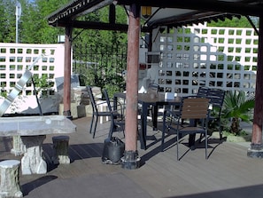 An outdoor patio with a table and chairs, a pergola, and a decorative fence. - Shanghai Xiangyu Guesthouse (Shanghai)
