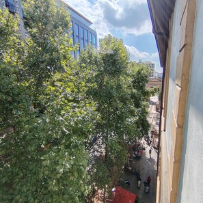 A view of a street with trees, a building with large windows, and a clear sky. - "Il Mondo Nuovo," a modern and cozy apartment in Porta Nuova. (Milano)