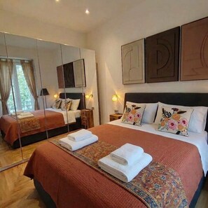 A hotel room with a large bed, a mirror, and artwork on the walls. - "Il Mondo Nuovo," a modern and cozy apartment in Porta Nuova. (Milano)