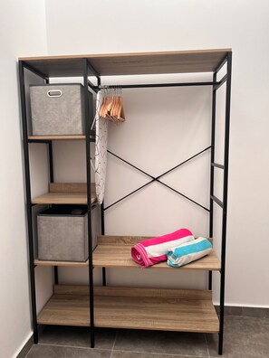 A room with a built-in wardrobe featuring multiple shelves, a hanging rack, and a fold-down bed. - Pescante 2 Apartment. Playa Honda (Playa Honda)
