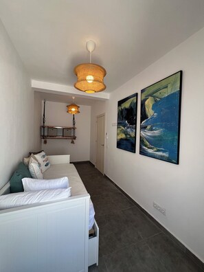 A hotel room with a white sofa, two paintings, a ceiling light, and a door leading to another room. - Pescante 2 Apartment. Playa Honda (Playa Honda)