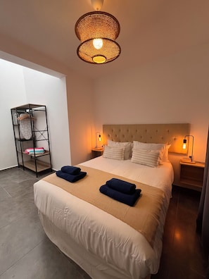 A hotel room with a large bed, two bedside tables with lamps, a wardrobe, and a hanging light fixture. - Pescante 2 Apartment. Playa Honda (Playa Honda)
