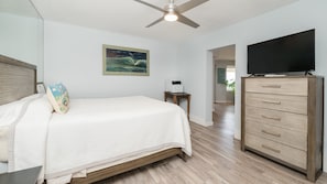 A bedroom with a bed, a dresser, a ceiling fan, a flat-screen TV, and a painting on the wall. - #3502  Ponce Inlet Oceanfront (Ponce Inlet)