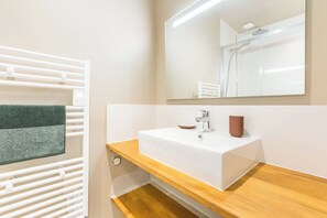 A bathroom with a white sink, a mirror, and a shower. - Luxueux Logement Design 4 ch Clim (Lille)