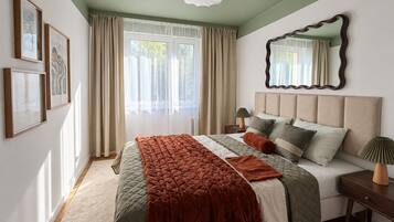 A bedroom with a large bed, a nightstand, a mirror, and a window with curtains.