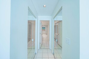 Ein Flur mit Glastüren zu einem Badezimmer und einem Schlafzimmer.