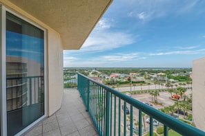Ein Balkon mit Blick auf ein Wohngebiet und einen klaren Himmel.