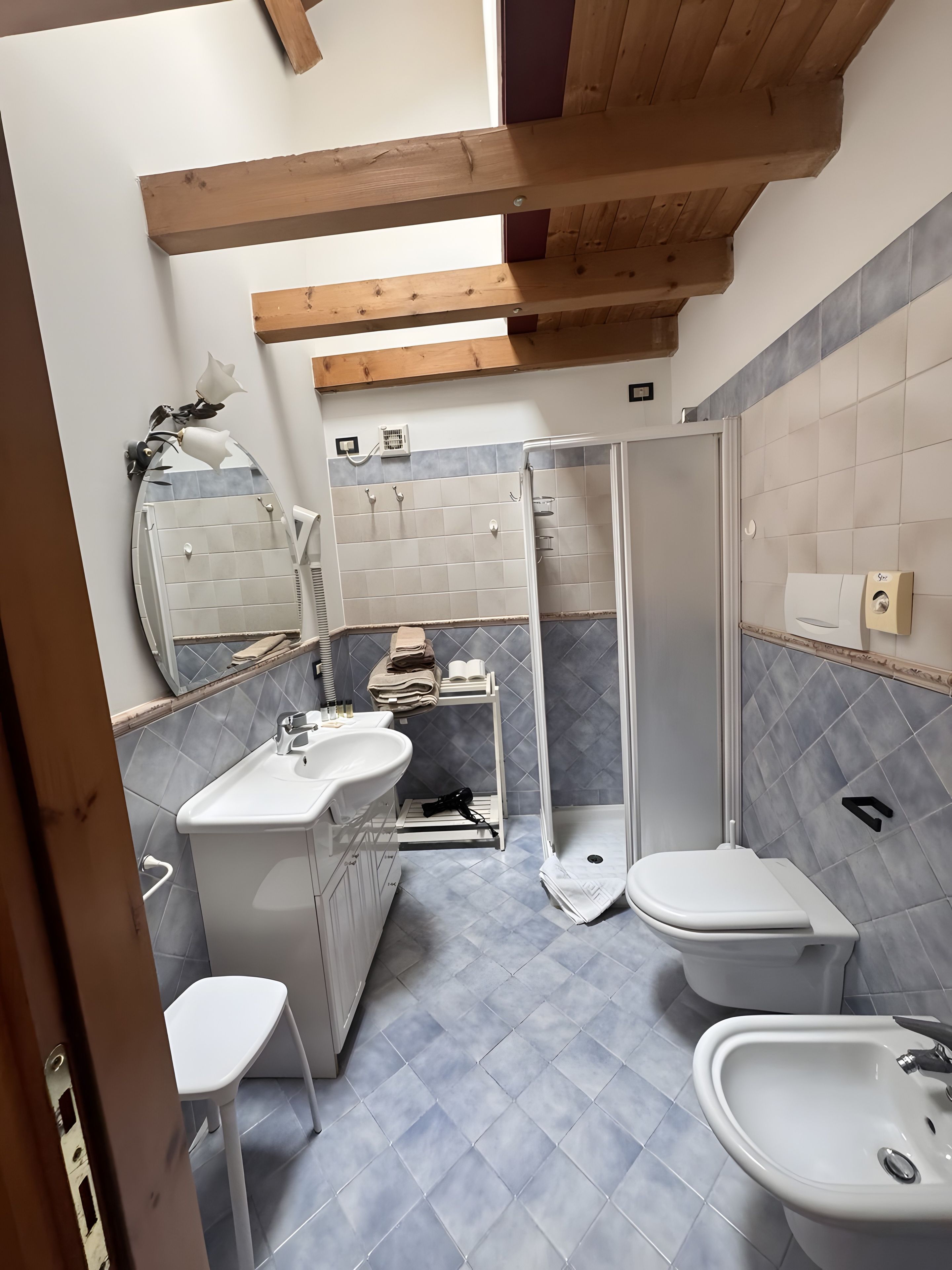 Ein Badezimmer mit Dusche, Toilette, Bidet und Waschbecken.