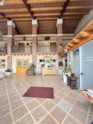 A spacious lobby with a high ceiling, a reception desk, and a large window. - Apartment 'Nonna Giuseppina - Bilocale' with Shared Pool, Wi-Fi and Air Conditioning (Romano d'Ezzelino)