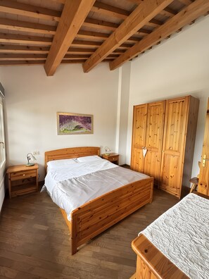 Un dormitorio con una cama de madera, una mesita de noche, un armario y un cuadro en la pared.