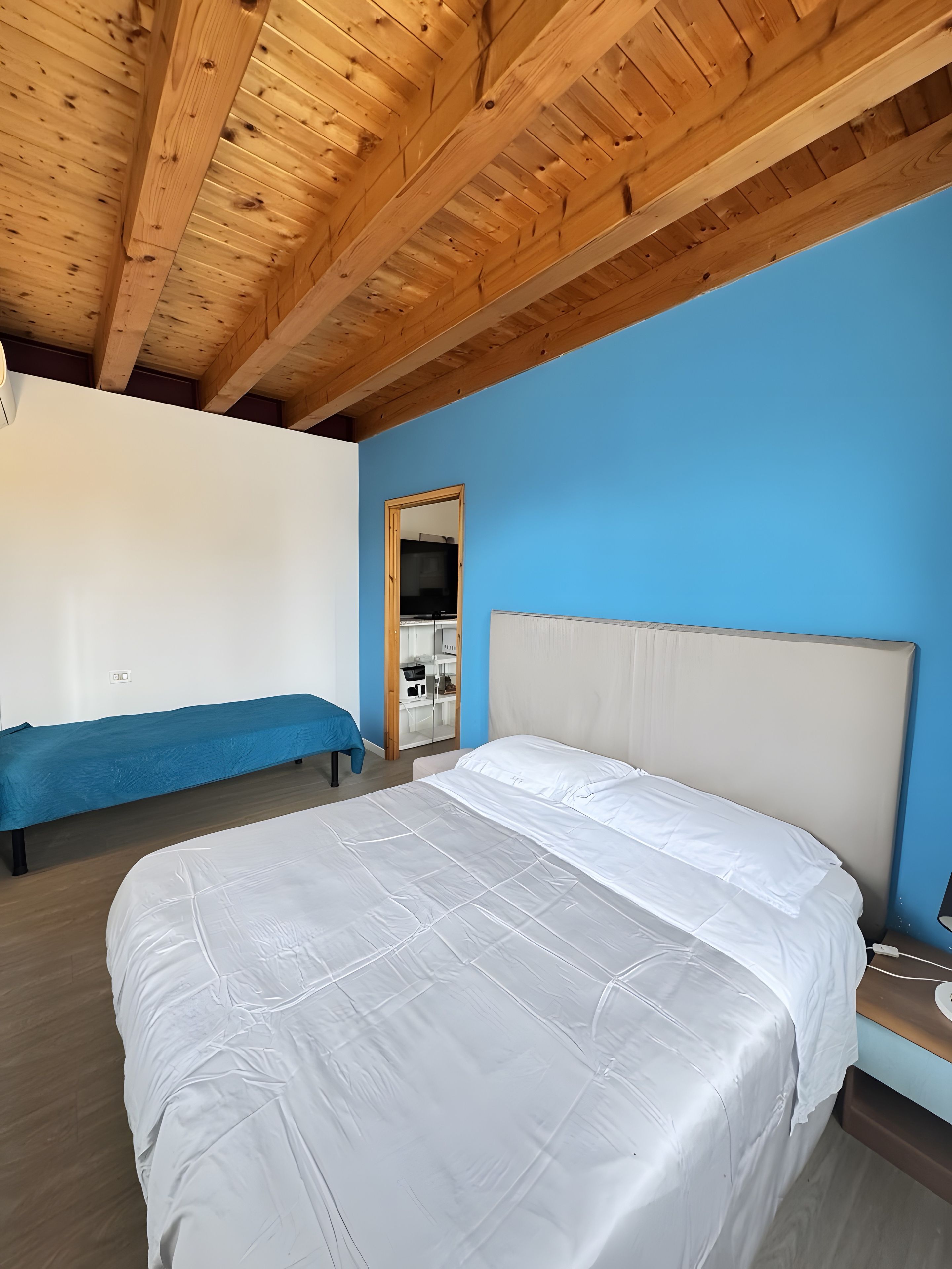 Ein Schlafzimmer mit einem Bett, einer Bank und einem Kleiderschrank.