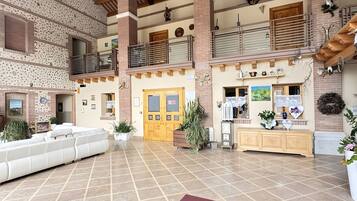 Un intérieur spacieux avec un plafond haut, un coin salon central et une cuisine avec vue.