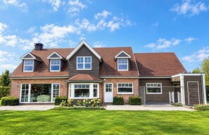 A two-story house with a brick exterior, a covered front porch, and a garage.