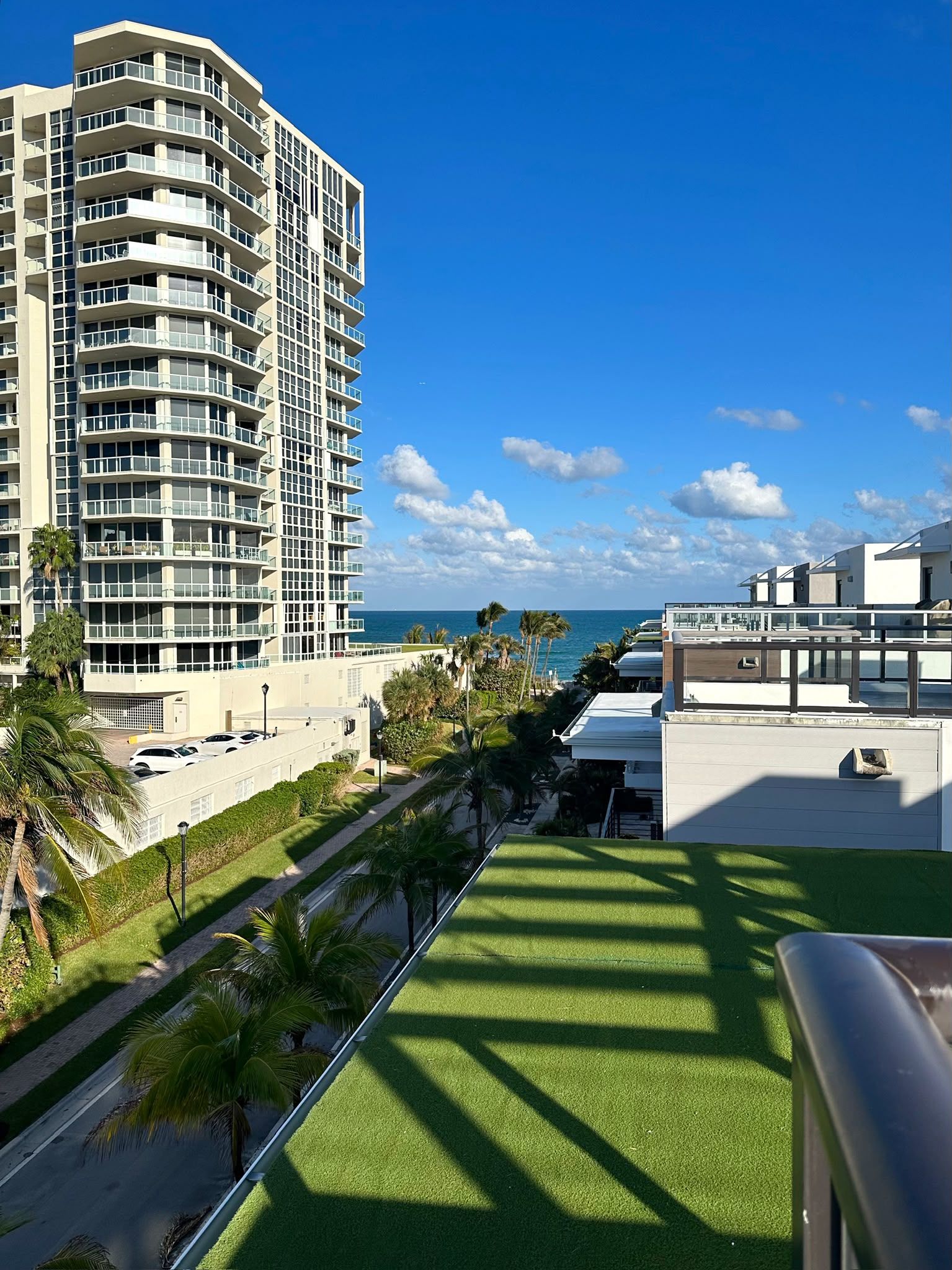 A high-rise building with multiple balconies overlooking a coastal area.