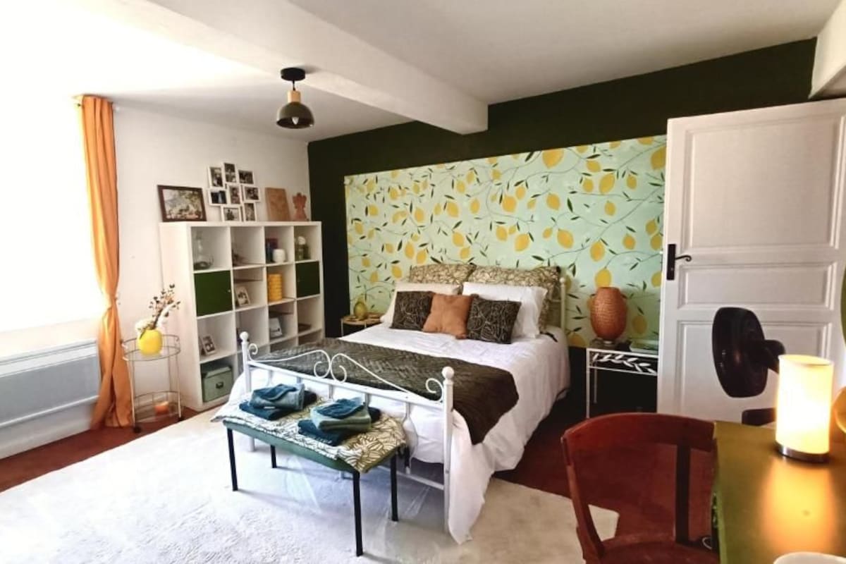 A bedroom with a bed, bedside table, chair, wardrobe, and a bookshelf.