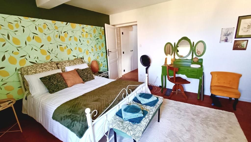 Un dormitorio con cama, mesita de noche, cómoda, silla y espejo.