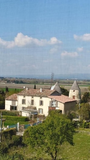 A two-story house with a tiled roof and a small tower-like structure. - Une bulle de bien être avec Spa (PEXIORA)