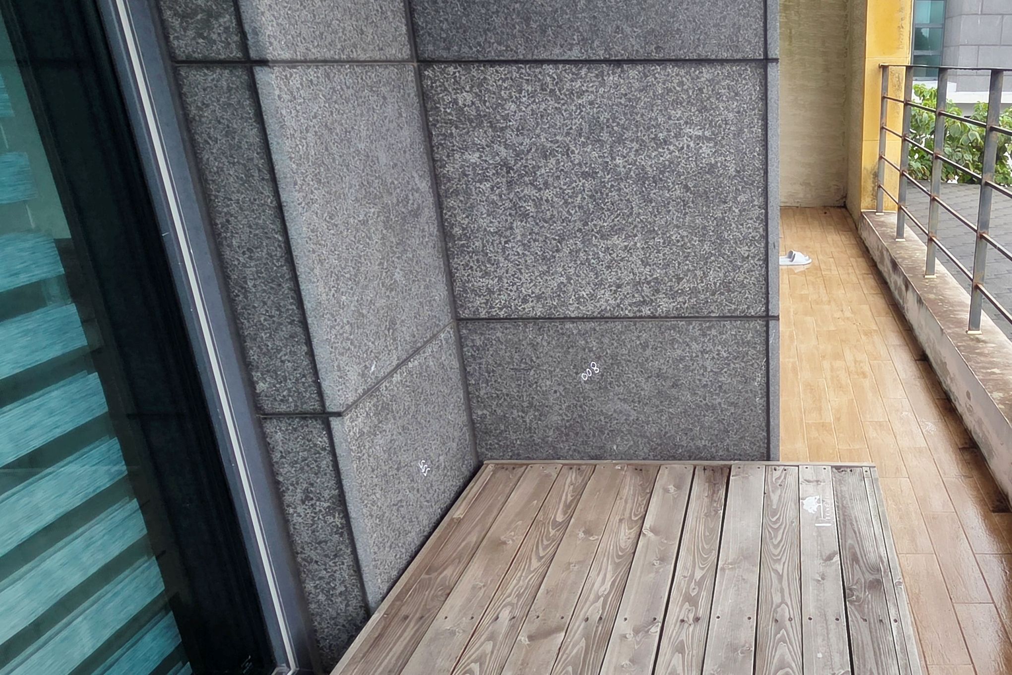 A corner of a room with a wooden table and grey stone walls.