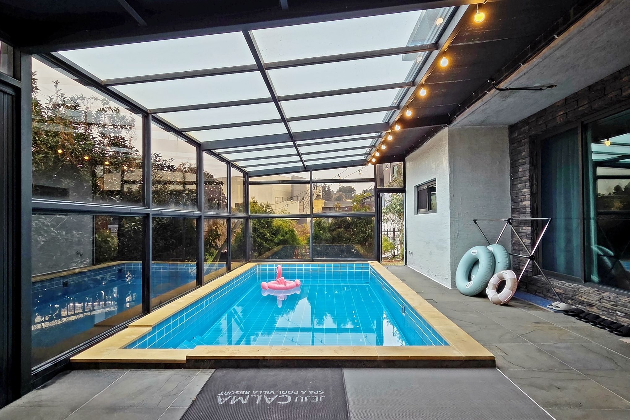 Une piscine intérieure, entourée de baies vitrées, offrant une vue dégagée sur les environs.
